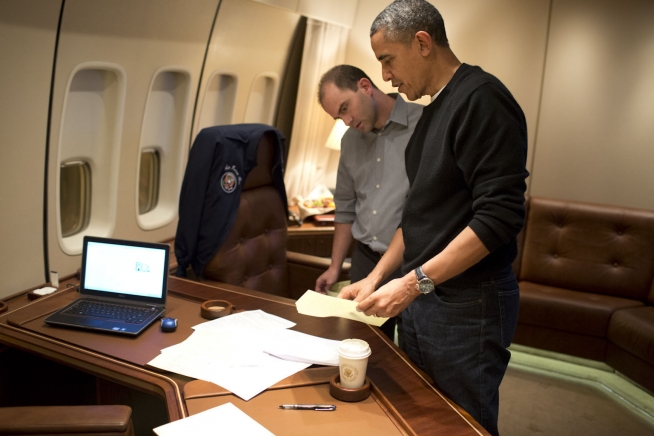Ben Rhodes and Barack Obama on board Air Force One editing the speech that the President will deliver at the Nelson Mandela memorial service in South Africa, 9 December 2013 (photograph via Wikimedia Commons)