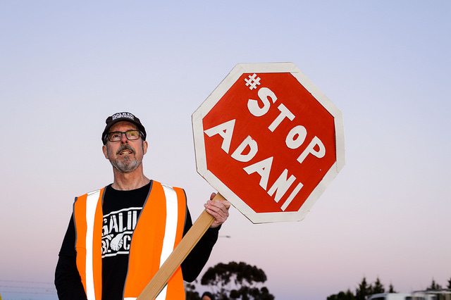 An activist at Melbourne's Downer Group Somerton in 2017, protesting the company's contractual commitments to build the Carmichael coal mine (photo by Julian Meehan/Flickr)