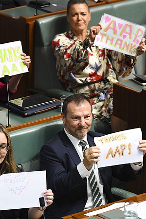 Labor MPs hold up signs in support of Australian Associated Press (AAP) during House of Representatives Question Time at Parliament House in Canberra, Tuesday, 3 March 2020. (AAP Image/Lukas Coch)
